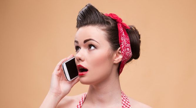 50's style woman with read paisley head band talking on a cell phone